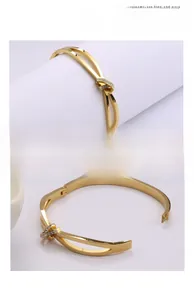 Détail d'un bracelet en acier titane doré avec nœud entrelacé et pavé de zircones