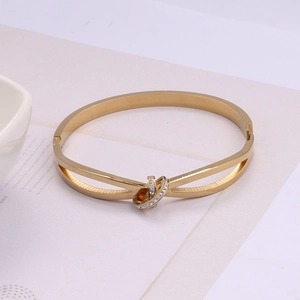 Détail du bracelet jon jonc doré en C avec des accents de strass scintillants