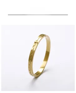 Detailed view of golden stainless steel bangle with engraved heartbeat wave pattern