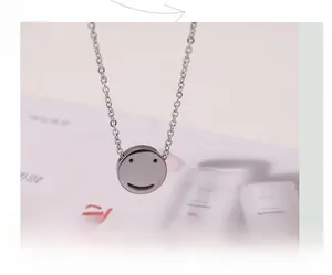 Macro detail of smiley face pendant with minimalist silver finish on fine link chain