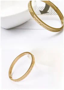 Detailed close-up of golden heartbeat pattern engraving on a polished steel cuff bracelet
