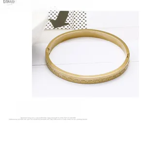 Macro shot of gold stainless steel bangle featuring engraved heartbeat pulse wave pattern