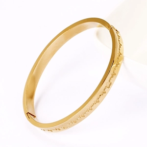 Polished gold stainless steel bangle with heartbeat engraving on white background