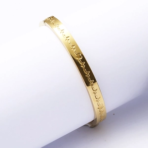 Gold stainless steel heartbeat bracelet with red heart engraving on white stand