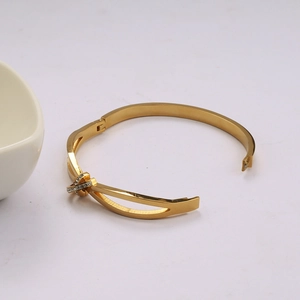 Bracelet jonc en acier inoxydable doré avec design croisé en C et strass brillants