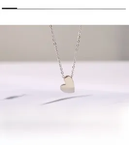 Gros plan d'un collier pendentif cœur en argent poli avec une chaîne délicate pour femme
