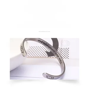 Macro shot of stainless steel cuff bracelet engraved with You are unstoppable message