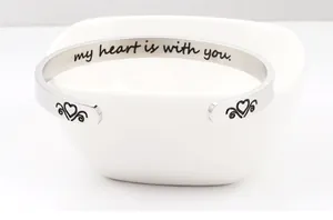 Macro detail of engraved inspirational text My heart is with you on stainless steel cuff