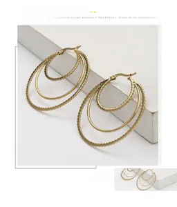 Detail view of triple hoop gold-plated earrings with beaded texture and polished finish