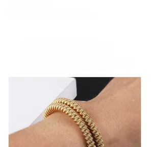 Detailed close-up of golden titanium steel twisted cable bangle showing spiral texture