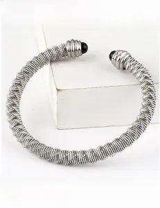 Detailed view of silver cable wire cuff bracelet with mirror finish and black ball ends