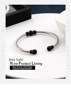 Macro detail of silver titanium steel cable bracelet with five polished black beads