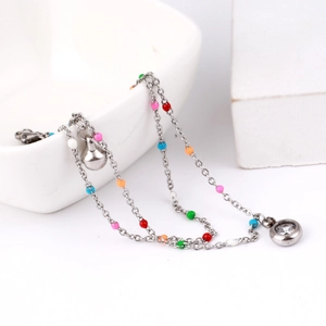 Detail of double-layer ankle chain with colorful beads, metal bell and zircon pendant