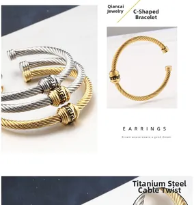 Macro detail of 18K gold cable twist bracelet featuring black Greek key pattern charms