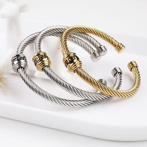 Detailed macro view of 18K gold and silver stainless steel cable twist bracelets set