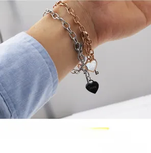 Detail of rose gold and silver heart bracelets with love engraving and shell charms