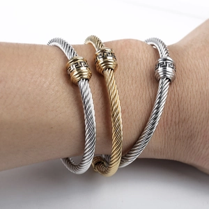 Detail of twisted cable bangles featuring classic Greek meander pattern on metal beads