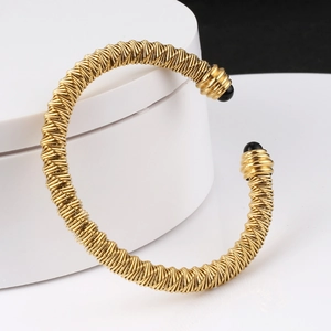 Golden stainless steel cable open bangle with woven texture and black bead ends