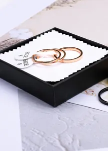 Detailed view of three rose gold titanium steel thin rings in a black jewelry box