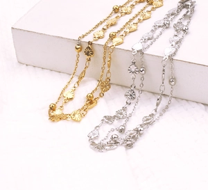 Detail of 18k rose gold layered anklets with heart charms on minimalist white stone