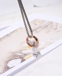 Detail of 2mm rose gold titanium steel thin ring with size tag hanging from a silver chain
