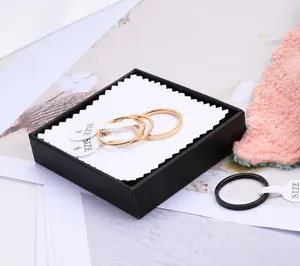 Detail of 2mm slim titanium steel rings in rose gold and black finish with size tags