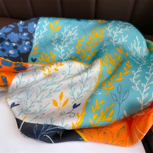 Détail d'un foulard en soie aux motifs floraux et texture de tissu lisse et brillant
