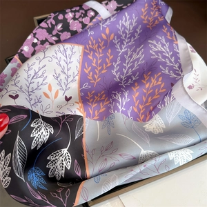 Détail du foulard effet soie avec imprimés floraux montrant la texture douce du tissu