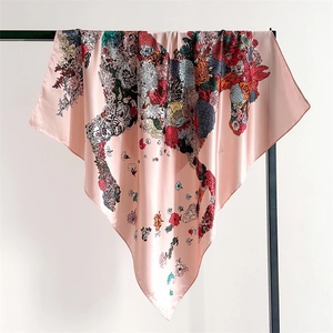 Detail of floral horse print silk scarf featuring pink satin fabric and bloom patterns