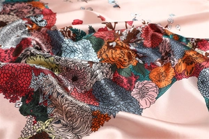 Close-up of pink satin scarf with vibrant floral horse prints and smooth glossy texture