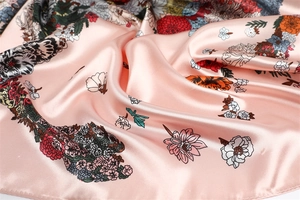 Detailed view of pink floral satin scarf featuring vibrant roses and soft silk-like luster