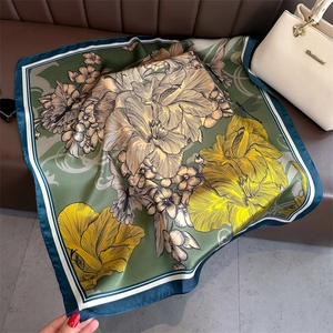 Détails d'un foulard en soie vintage aux imprimés floraux de lys verts sur du cuir