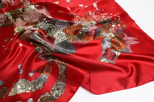 Detailed view of red floral satin scarf featuring high-gloss texture and flower print