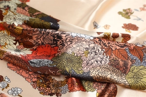 Macro detail of satin silk scarf featuring vintage floral prints and elegant drape