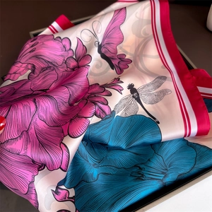 Gros plan détaillé du foulard en soie avec pivoines roses et motifs papillons