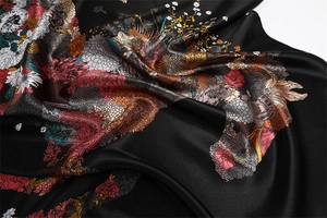 Macro detail of glossy satin scarf with vibrant floral horse prints and elegant draping