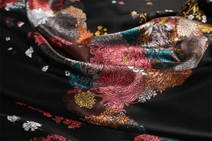 Detailed close-up of glossy floral satin scarf with pink peony and green leaves