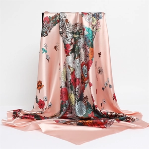 Detail of silk square scarf featuring elegant floral and horse patterns on pink background