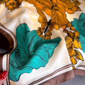 Gros plan du foulard en soie vintage avec imprimé floral, papillon et finition satinée