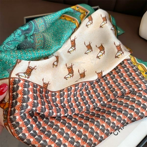 Macro detail of silk scarf showing horse print, geometric patterns and glossy texture