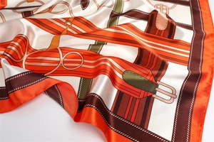 Detailed view of the equestrian print and smooth satin texture on the vintage silk scarf