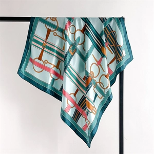 Close-up of vintage equestrian silk scarf showing satin texture and geometric horse patterns