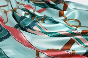 Close-up of vintage chain pattern silk scarf with elegant mint green and coral drapes