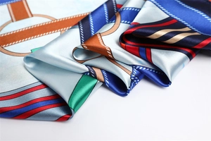 Close-up of silk-satin scarf detail showing retro geometric patterns and vibrant horse motifs