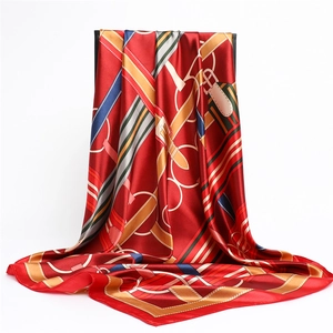 Detail of red satin scarf with vintage equestrian strap and harness print texture