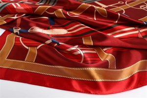 Detailed macro shot of luxury red silk scarf featuring classic equestrian harness patterns