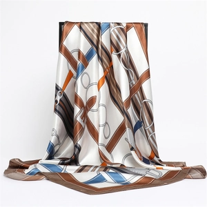 Detail of a large silk square scarf featuring equestrian chain and leather buckle prints