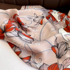 Gros plan détaillé du foulard en satin à motif floral avec magnolias et texture soyeuse