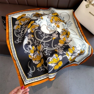 Détail d'un carré de soie avec motifs cachemire floraux et finition à bord roulé orange