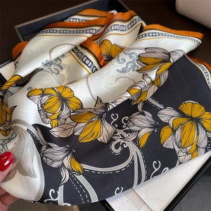 Détail d'un foulard en soie de luxe avec imprimé floral jaune et motifs géométriques élégants